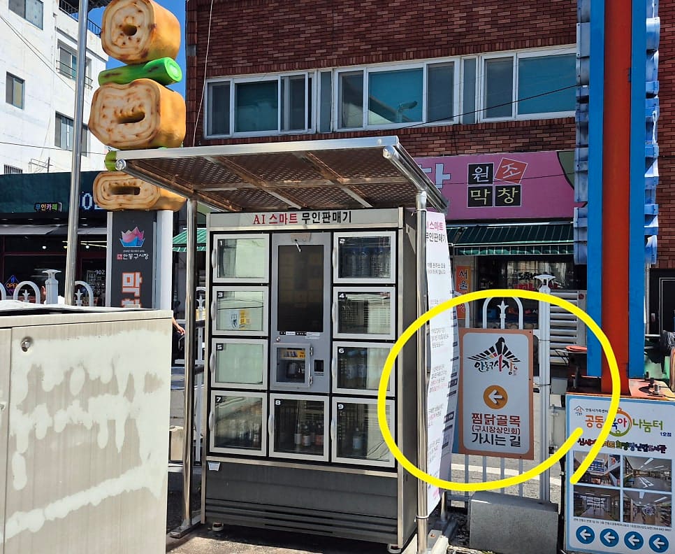 soulfulog가 찍은 골목 천장의 안동찜닭 간판과, 바깥 공영주차장 쪽 안내판입니다. 유진찜닭·현대찜닭·우정찜닭·중앙찜닭 간판이 한 장에 함께 걸려 있고,