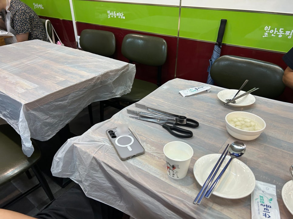 qkrdusqls님이 남긴 테이블과 찜닭 한 상입니다. 벽면에 원안동찜닭이라는 글자가 보이고, 메뉴는 단일 메뉴라 고민 없이 중자를 보통맛으로 주문했다고 적었습니다.