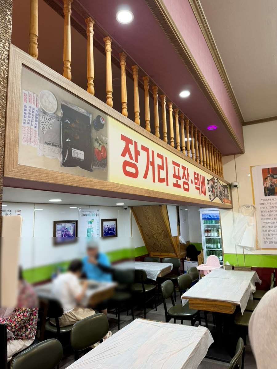 ek9705님이 찍은 매장 내부와 벽에 걸린 창업 내력 안내문입니다. 장거리 포장·택배 안내판 아래로 테이블이 늘어서 있고,