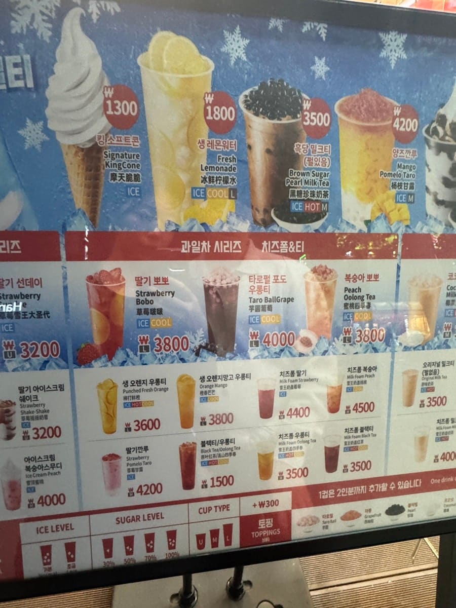 kyj9625는 매장 한쪽을 지키고 선 왕관 쓴 눈사람 모형과, 벽을 가득 채운 메뉴 스크린을 함께 찍었다. 소프트콘부터 흑당 밀크티까지,
