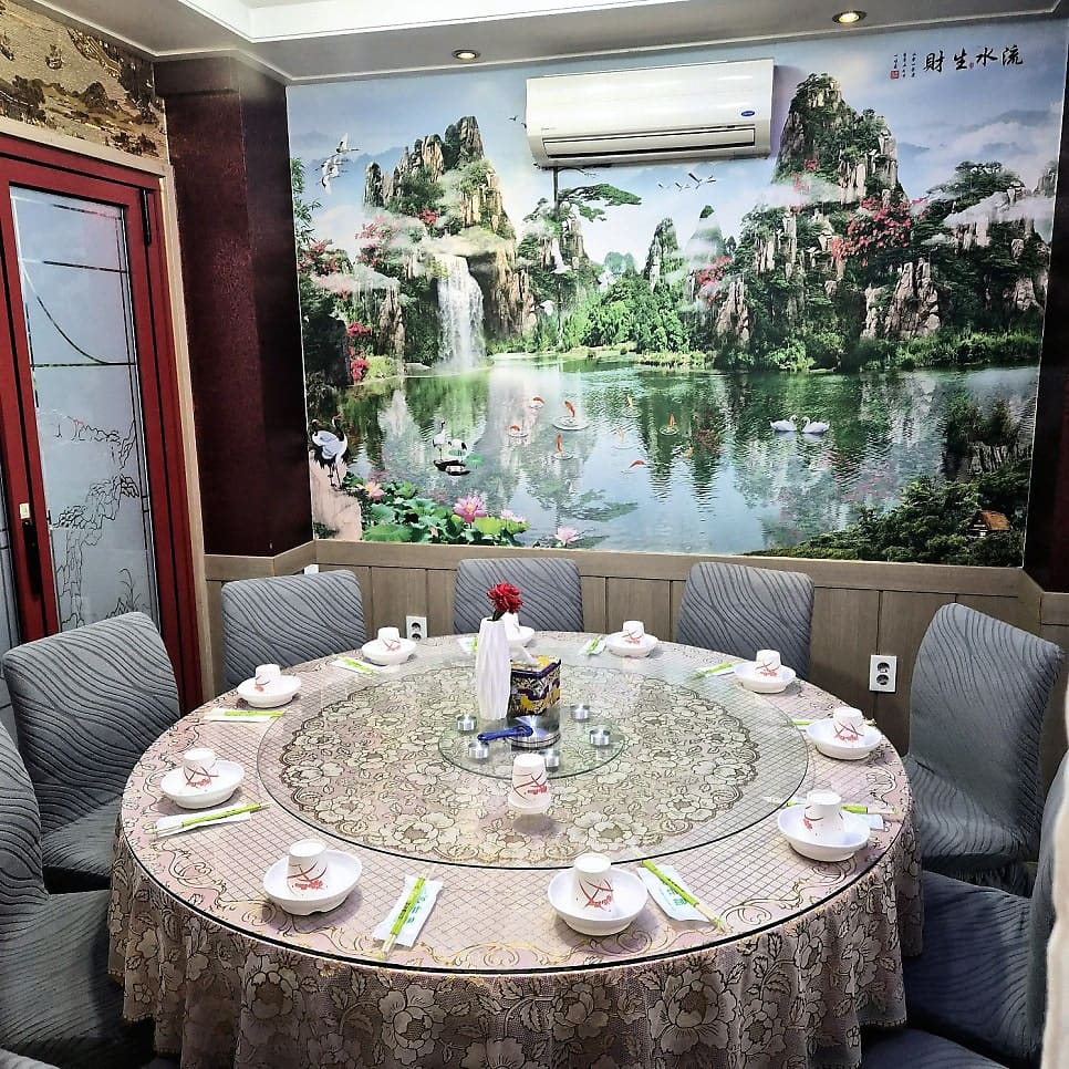 kimgamanii는 '안산의 맛집' 보라색 표지판과 중국 국기가 그려진 다문화음식점 표지를 함께 찍고, 안쪽 룸의 중국 산수화 벽지와 회전판 테이블도 따로 담았다.
