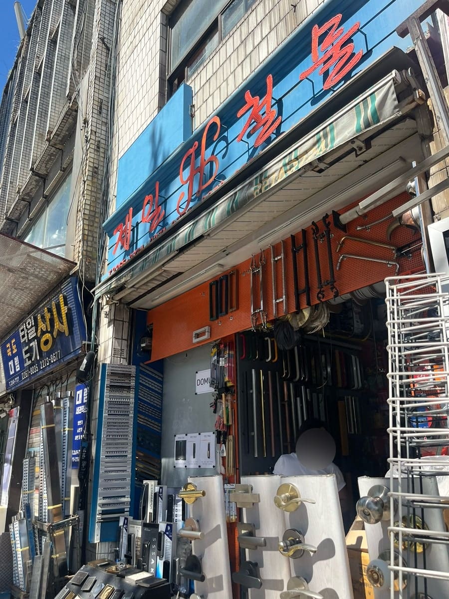도배지 도매 가게와 철물 도매 가게입니다. 개인 손님이 한 골목에서 여러 자재상을 훑고 지나가는 동선을 보여줍니다.
