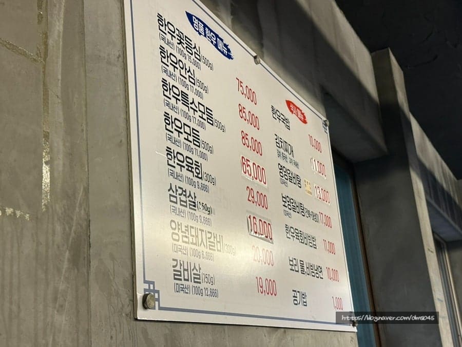 dms1045가 벽에 걸린 메뉴판을 찍은 사진입니다. 한우꽃등심과 한우안심, 한우특수모둠 같은 한우 메뉴와 삼겹살, 갈비살 같은 구이 메뉴,