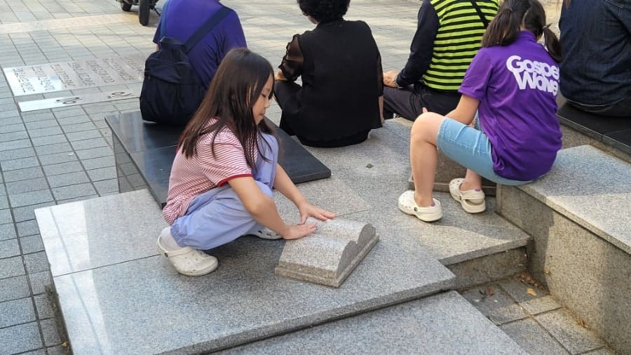 다른 방문자는 책을 가득 안은 동상과 그 앞 벤치에 걸터앉아 책장을 넘기는 아이들을 함께 담았습니다. 보도블록에 새겨진 세계 문학 작품의 제목을 발로 밟으며 걷다가,