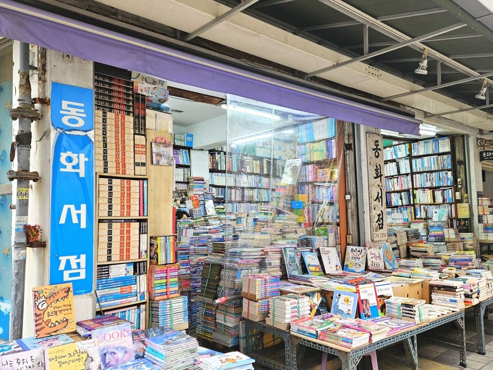 책 더미를 품에 안은 손정린씨의 동상이 골목 초입, 책방골목길 표지판 아래에 서 있다. 계단 옆 동화서점 매대에는 아이들 책이 가득 쌓여 있다.