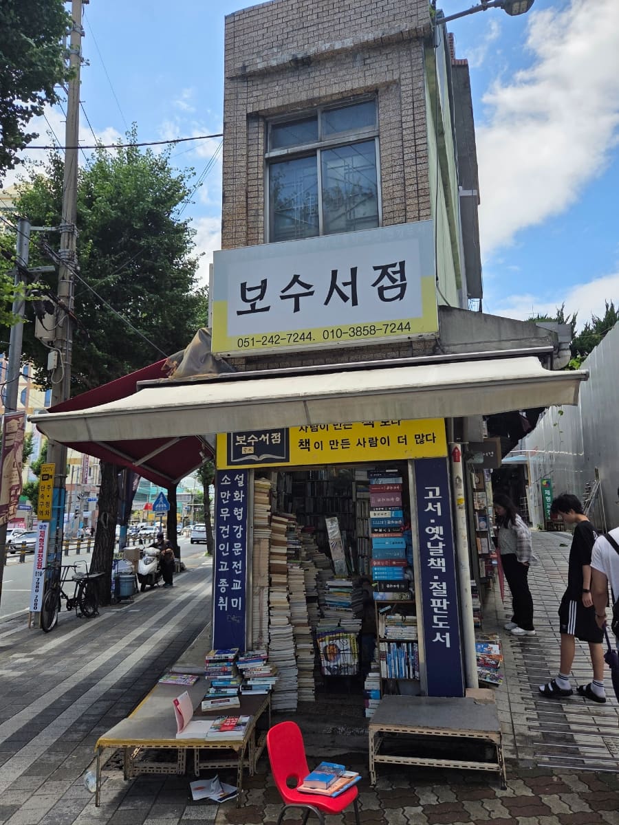 보수서점 모퉁이 간판과, 좌판 위에 책을 쌓아 올린 골목 안쪽 풍경이다. 지금도 문을 여는 서점들이 볕 좋은 날 거리로 책을 내놓는다.