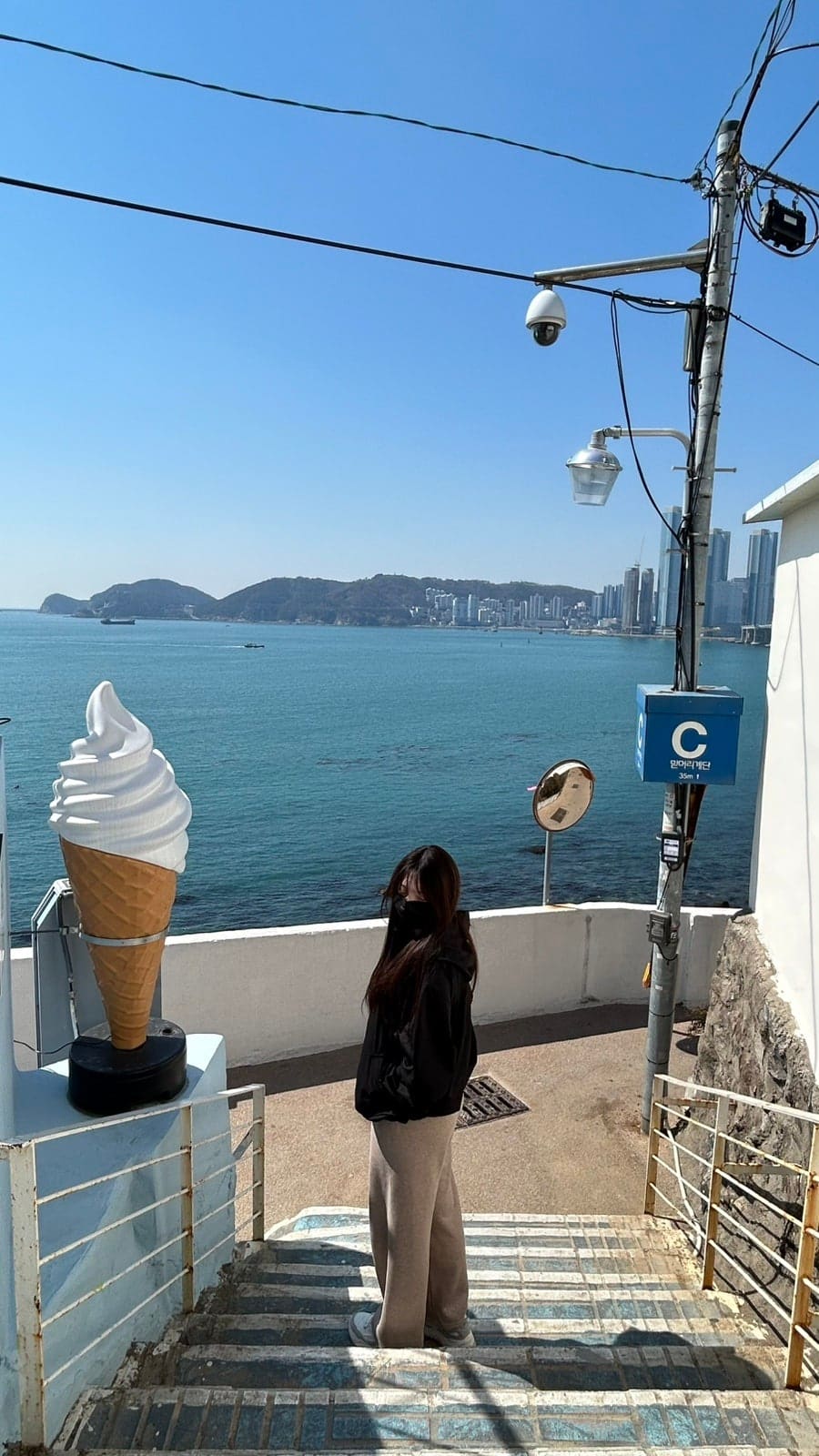 srad1340 님과 skswls0307 님이 남긴 터널 가는 길입니다. 커다란 아이스크림 조형물과 '흰여울' 팻말이 붙은 흰 건물을 지나면 좁은 골목이 바다 쪽으로 이어집니다.