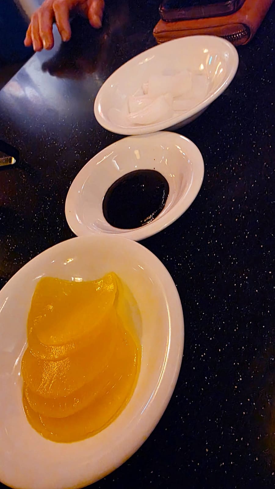 huyang00이 자리에 앉아 담은 사진입니다. 생수 대신 나온 자스민차를 금속 주전자에서 따라 마시는 손, 그리고 단무지·양파·춘장이 깔끔하게 담긴 기본 찬까지.