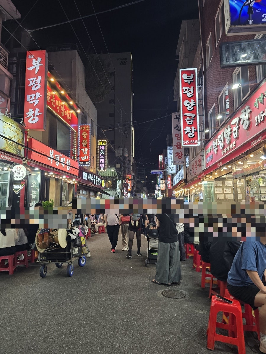 dodddllllll과 dlsdj928이 각각 찍은 가게 앞과 밤의 곱창골목입니다. 빨간 플라스틱 의자가 놓인 야외 테이블과,