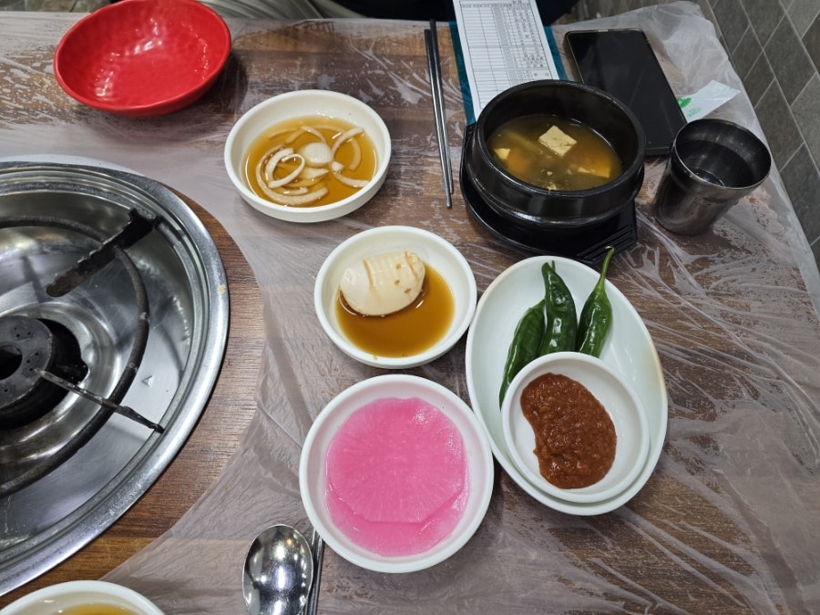 dodddllllll이 찍은 손님으로 가득 찬 실내와, dlsdj928이 받은 기본찬 상차림입니다.