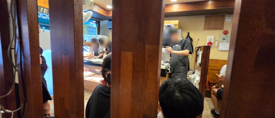 huper03이 찍은 홍소족발 내부입니다. 나무를 많이 쓴 인테리어가 세월을 보여주고, 매장은 손님들로 가득 차 있습니다.