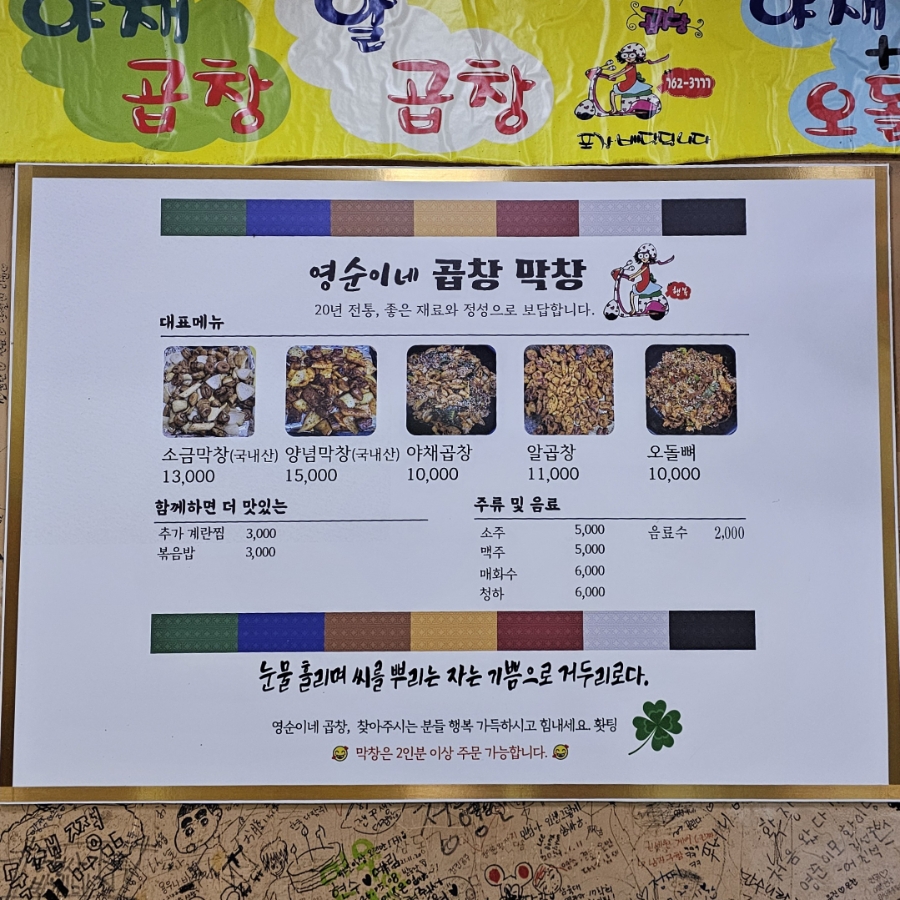 노란 배너를 배경으로 메뉴판이 벽에 붙어 있고, 20년 전통이라는 문구와 함께 대표 메뉴 다섯 가지가 실려 있습니다. 은박 쟁반 위에 양파와 곱창, 막창이 함께 구워져 나왔습니다.
