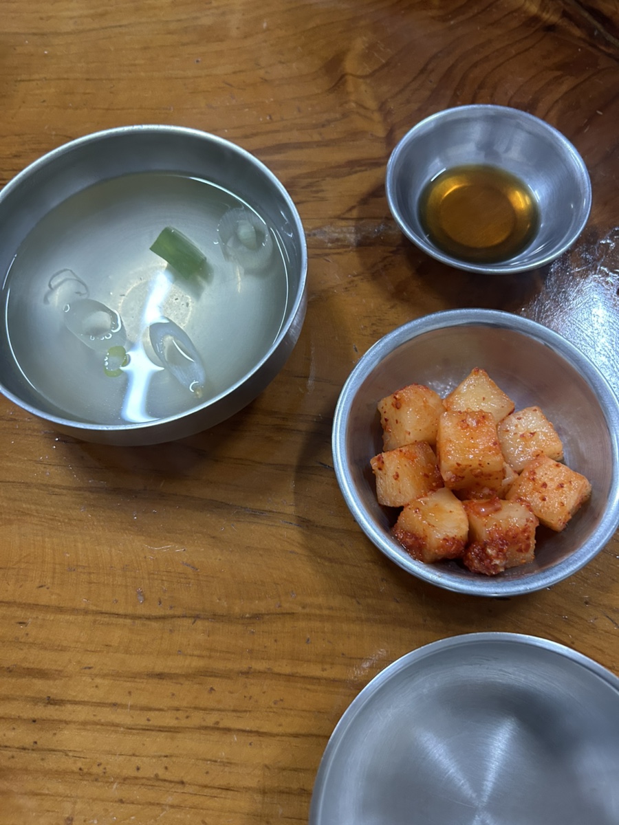 hankong__이 담은 매장 안 연혁 안내판과 떡볶이·김밥 상입니다. 1971년 간판 없이 시작해 3대를 거쳐 온 가게의 내력이 사진 속 안내판에 그대로 정리돼 있습니다.