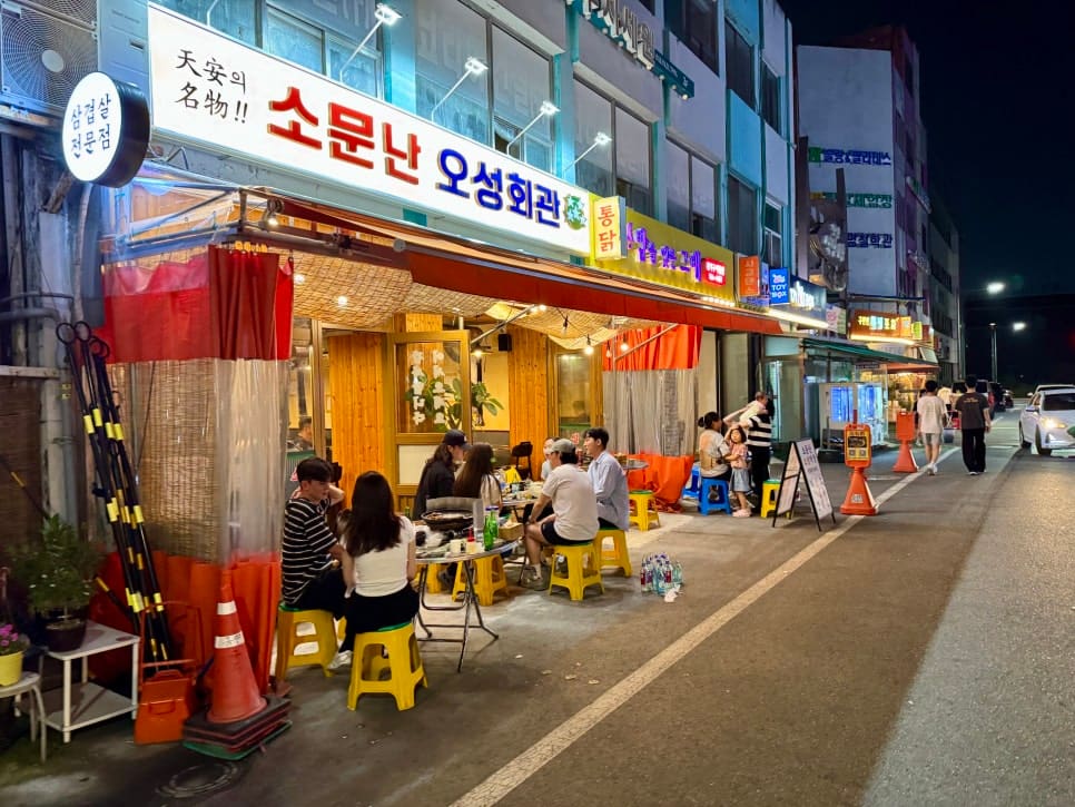 k5727710이 문화로의 포차거리를 찾아 찍은 사진입니다. 노란 플라스틱 의자와 천막 조명이 늘어선 가게 앞으로, 옆 건물의 통닭집 간판까지 이어지는 밤거리가 담겼습니다.