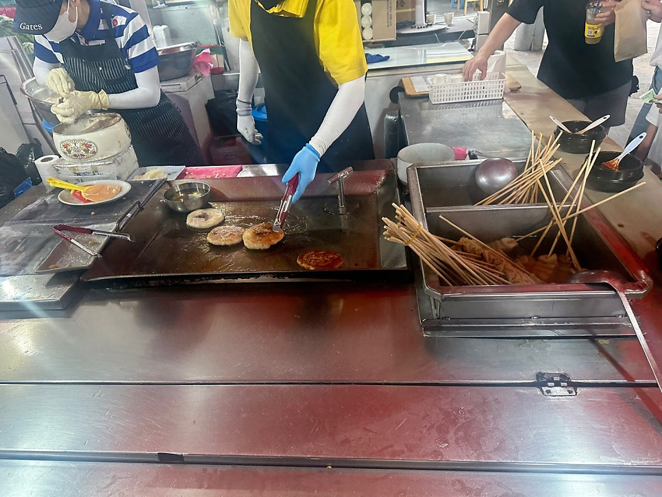 qordlsrms는 사장님이 철판 위에서 호떡과 오뎅을 함께 굽는 손놀림을 가까이서 찍었고, diyoning은 김이 오르는 호떡 여러 장이 노릇하게 구워지는 순간을 담았습니다.