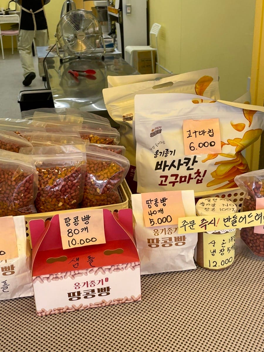 매장 안쪽, 포장된 땅콩빵과 땅콩 제품들이 진열된 모습입니다. 40개 5,000원, 80개 10,000원짜리 포장 박스가 쌓여 있습니다.