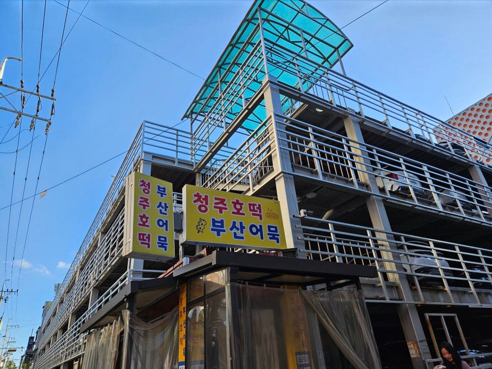 성안길 소금빵 가게 원미당 주변을 찍은 woniovehotwo의 사진입니다. 옆 건물 옥상에는 청주호떡·부산어묵을 함께 파는 간판이 걸려 있고,