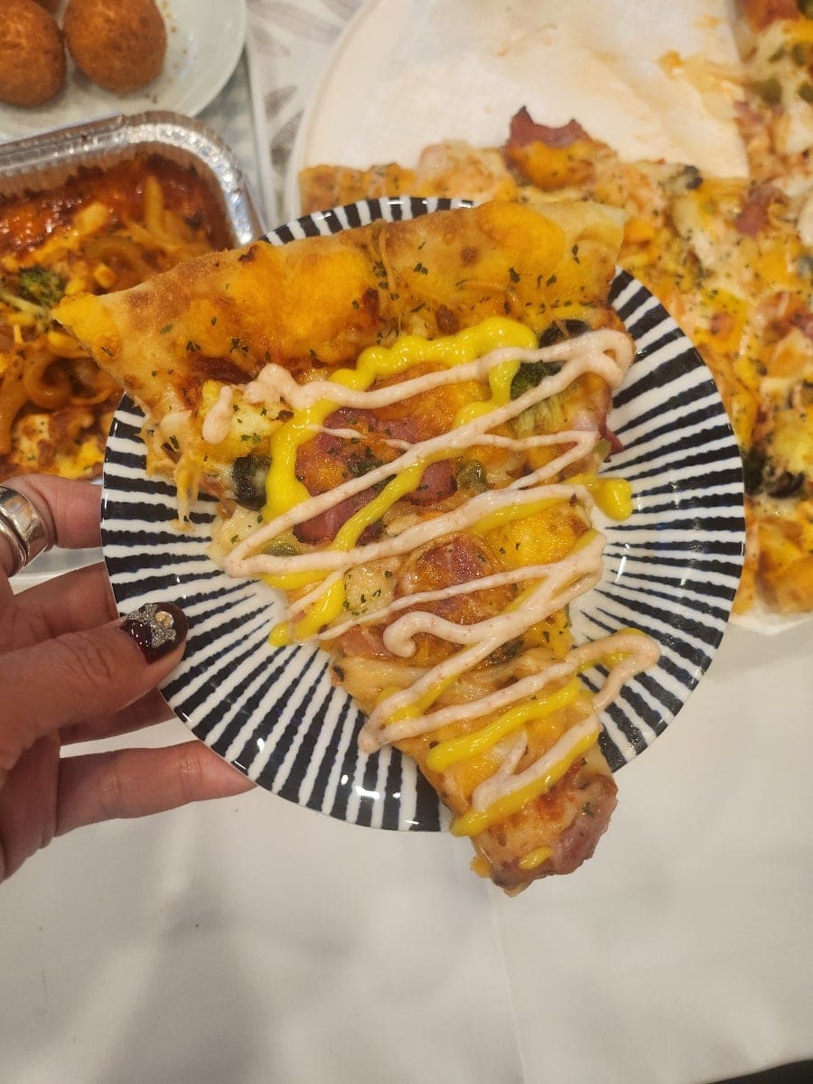 lilyshop83이 찍은 반반 피자 조각입니다. 새우 토핑과 베이컨체다치즈 토핑이 한 판에 절반씩 올라가, 치즈가 늘어지는 모습까지 담겼습니다.