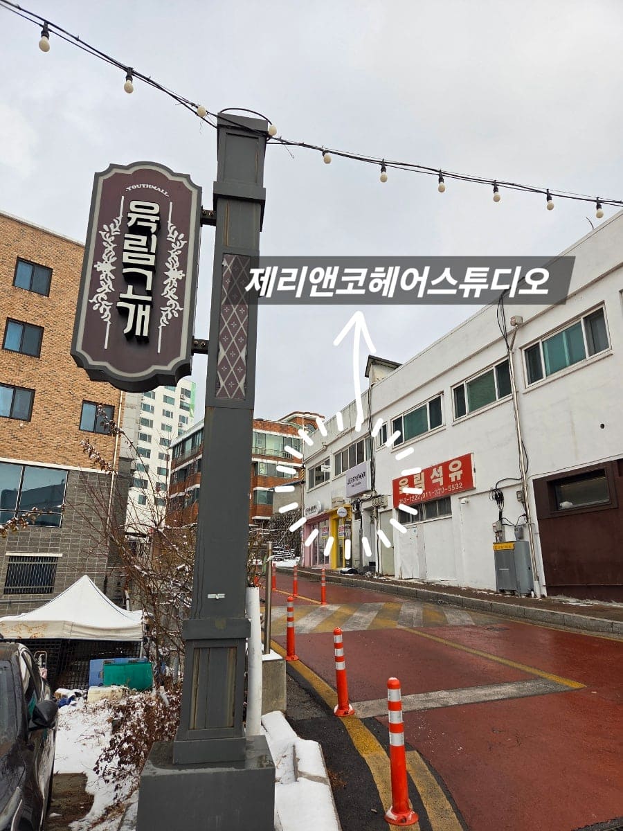 같은 방문에서 kmh8104이 찍은 계단 위 풍경입니다. 육림고개 조형 간판 옆으로, 2층에 자리한 미용실 건물이 올려다보입니다.