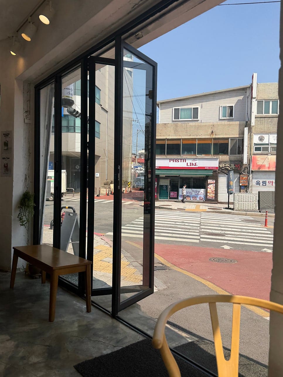 같은 방문에서 shinsoju_가 찍은 매장 안쪽 풍경입니다. 통유리문 너머로 맞은편 파스타 가게와 약국 간판이 보입니다.