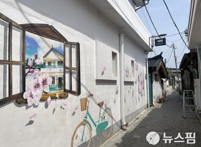 opipeyag가 해 질 무렵 관아골을 걸으며 찍은 사진입니다. 노란 불빛이 켜진 가게 안쪽과, 그 옆으로 이어지는 조용한 골목이 낮과는 다른 저녁의 표정을 보여줍니다.