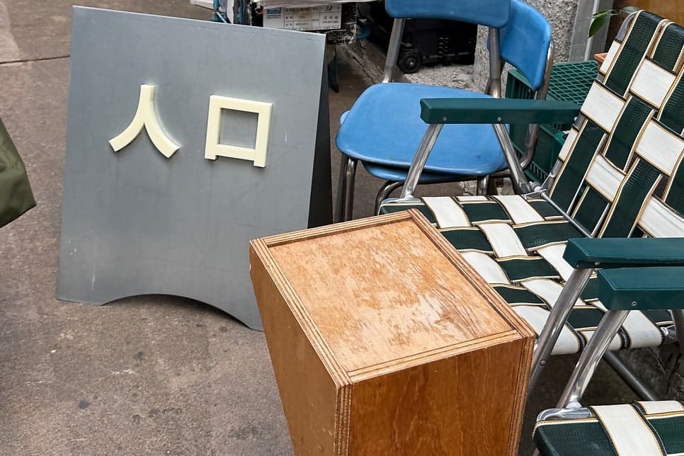 핸드드립과 크림라떼, 레몬 치즈케이크를 담은 테이블. 가게 밖에는 '人口'라고 적힌 입간판이 접이식 의자 옆에 놓여 있다.
