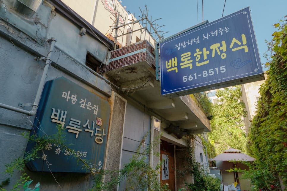 한쪽은 백록식당의 오래된 파란 간판, 다른 한쪽은 오디너리하우스 종로점 안쪽에 걸린 새 간판이다. 하나는 수십 년째 같은 자리에서 한정식을 내고,