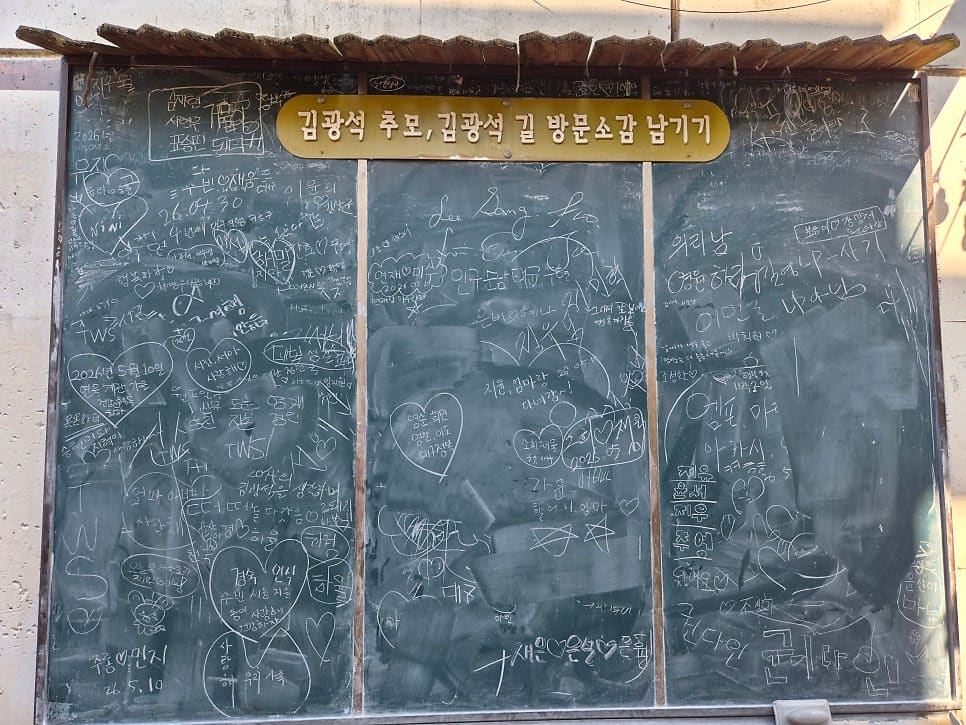 youtop344가 촬영한 벽화 골목과 방문객 칠판입니다. 벽면 가득한 그의 얼굴 옆으로, 다녀간 이들이 직접 남긴 추모와 방문 소감이 칠판 가득 적혀 있습니다.