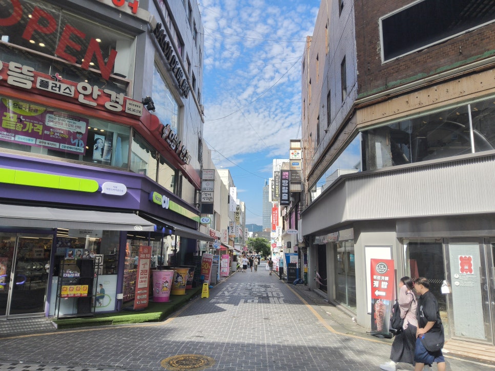 mudriy가 문화의 거리 행사일에 남긴 사진입니다. 한쪽은 사람이 드문 낮 시간 뒷골목, 다른 한쪽은 노점 앞에 사람들이 몰린 북적이는 구간으로,