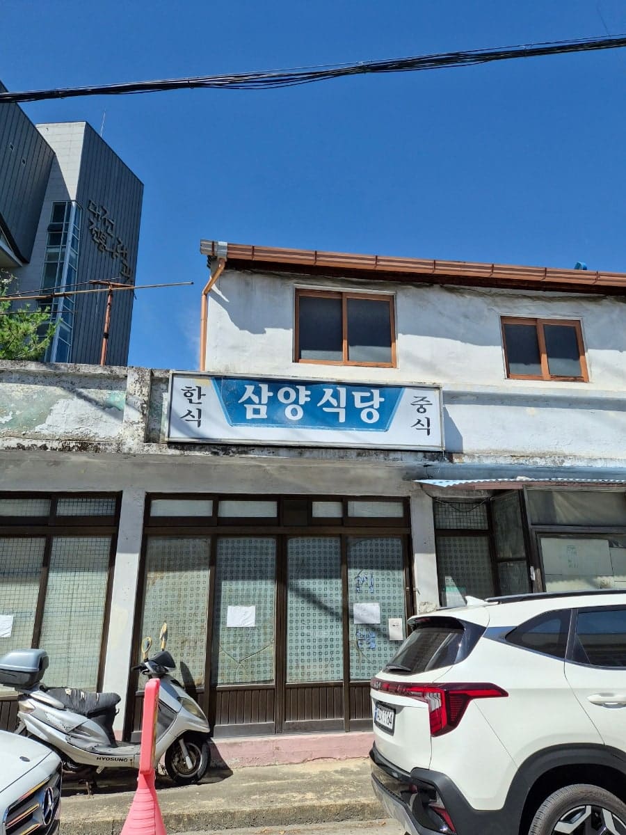 chaeunsoon2가 담은 골목 안쪽 옛 가게들입니다. 이 층짜리 오래된 식당 앞에는 오토바이와 승용차가 나란히 서 있고,