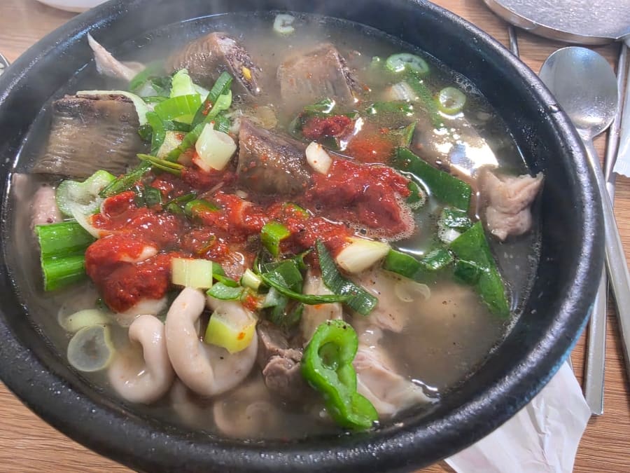 뚝배기 가득 고기와 대파, 붉은 다대기가 올라온 국밥 두 그릇입니다. 손님은 다대기를 바로 섞지 않고 맑은 국물부터 몇 숟가락 떠먹어 본 뒤,