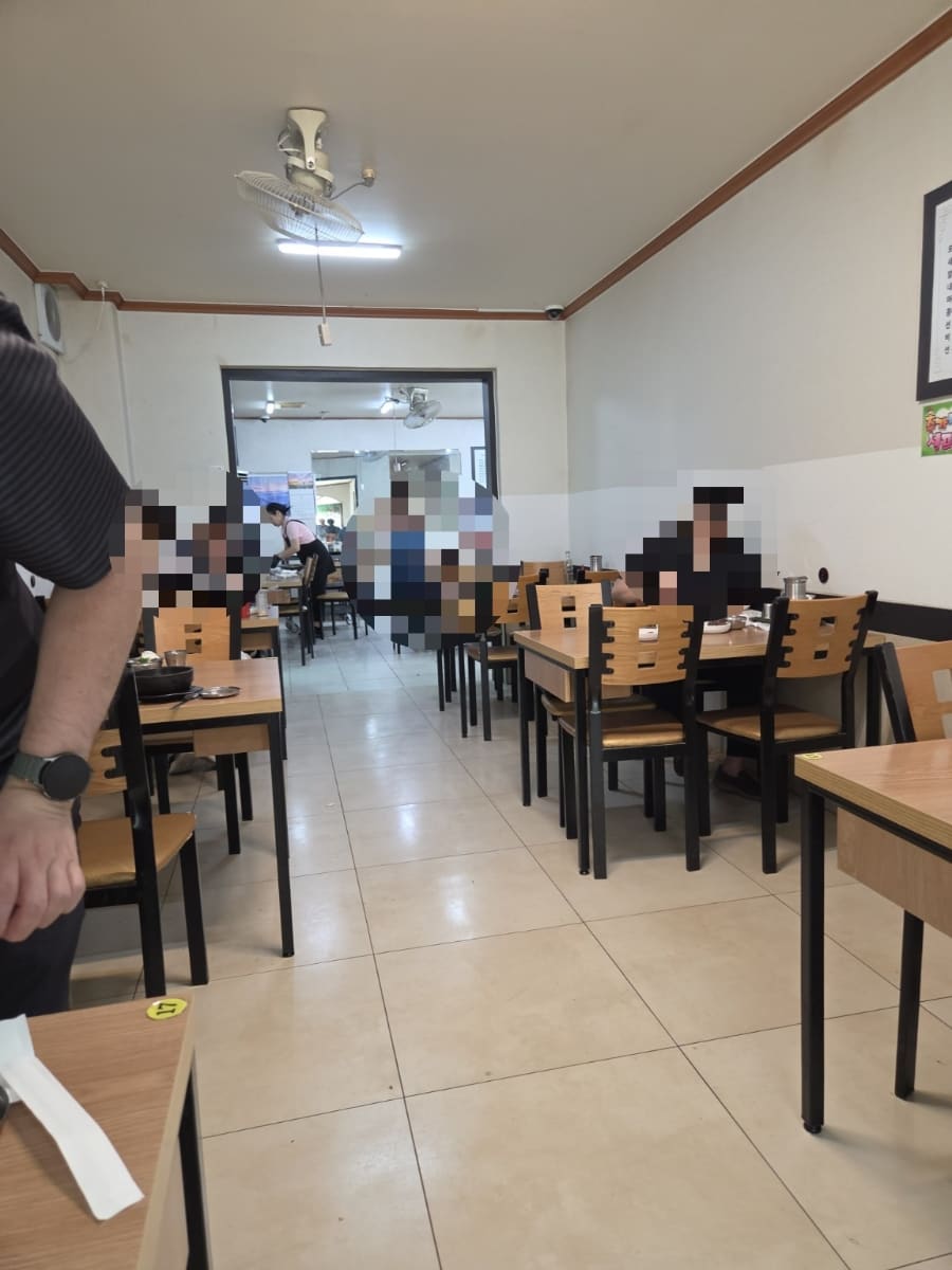 벽에 걸린 메뉴판에는 모듬국밥부터 막창전골, 소주와 복분자까지 가격이 빼곡합니다. 다른 사진은 안쪽까지 좌석이 이어진 매장 내부로,