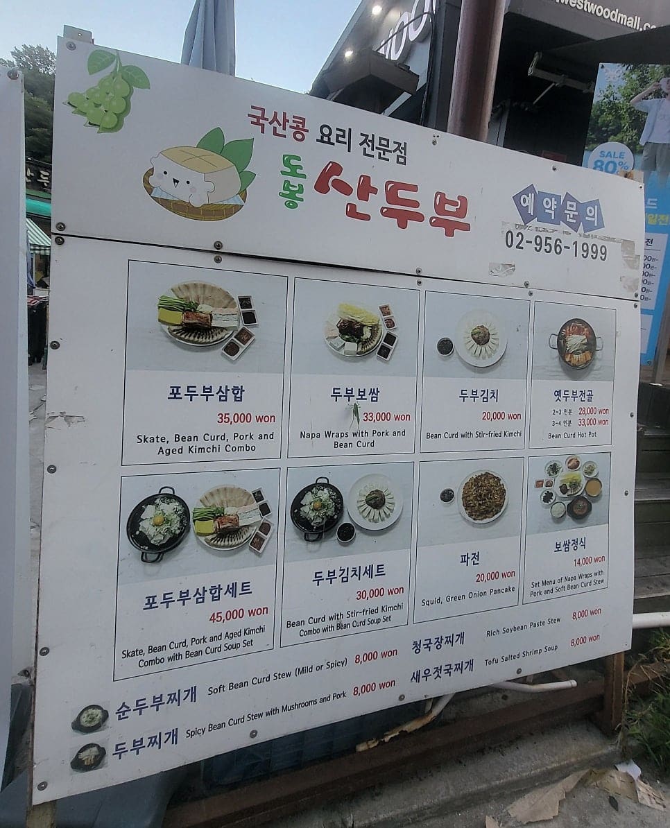 worthlog는 7년째 이 집을 찾는 단골입니다. 가게 앞에 세워진 메뉴판을 담았는데, 포두부삼합 35,000원부터 보쌈정식 14,000원까지 가격이 큼직하게 적혀 있습니다.