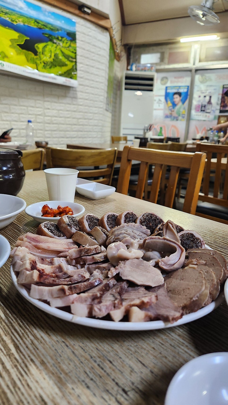tollgate777은 가게 벽에 걸린 초록색 메뉴판과, 순대모둠 한 접시가 놓인 나무 테이블을 찍었습니다. 메뉴판에는 순대국밥부터 모둠, 포장 가격까지 빼곡히 적혀 있고,