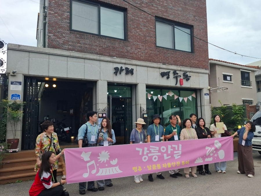 명주동이라는 이름을 그대로 간판에 새긴 건물. 강릉안길 골목투어 참가자들이 이 앞에 모여 설명을 듣는다. 이름 하나가 지역 해설의 소재가 될 만큼,