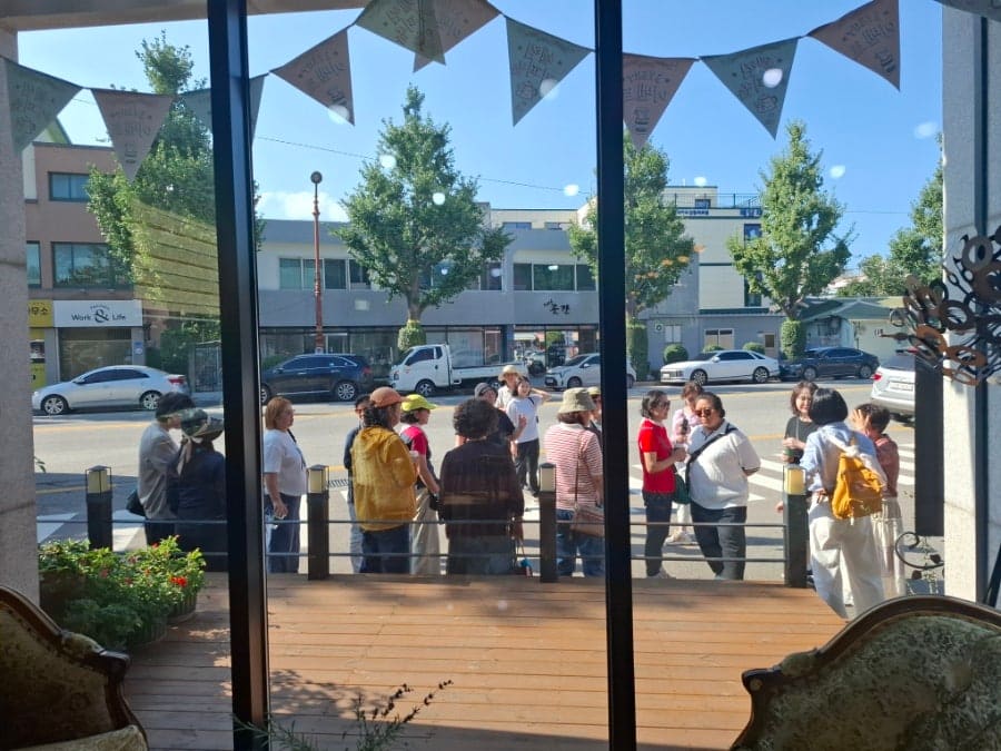 간판을 새로 단 건물과 그 옆으로 이어지는 좁은 도로. 큰길 버스정류장에서 몇 걸음만 들어오면 이렇게 낮고 조용한 골목이 시작된다.