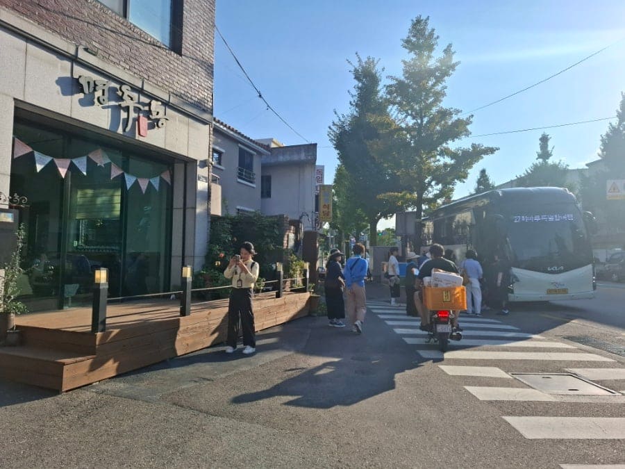 간판을 새로 단 건물과 그 옆으로 이어지는 좁은 도로. 큰길 버스정류장에서 몇 걸음만 들어오면 이렇게 낮고 조용한 골목이 시작된다.