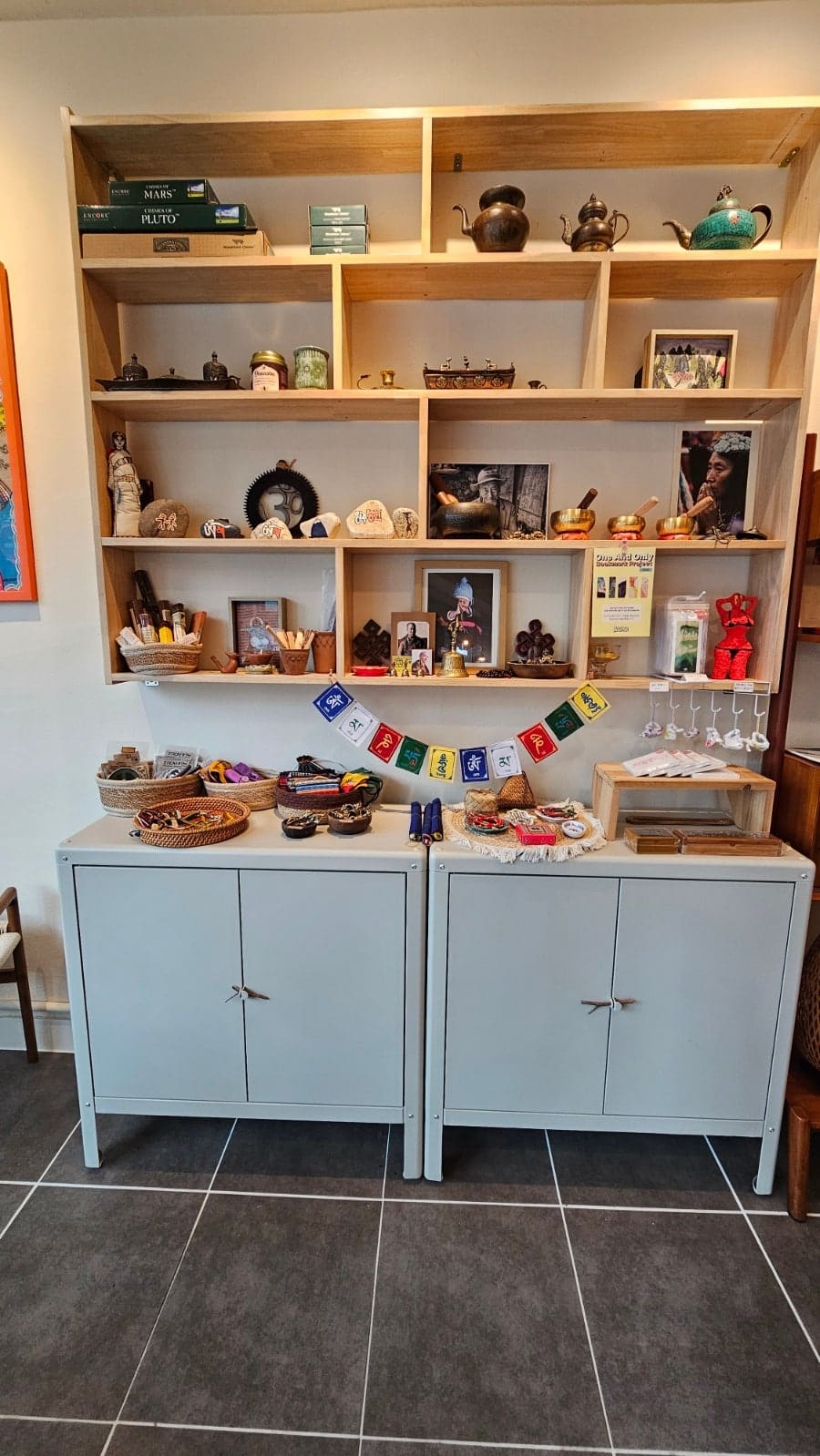 ratbell은 얼마 전 이전한 새 자리에서 'CHAI STALL'이라 적힌 오렌지색 노점 모형과 빼곡한 책장을 함께 담았습니다. 티베트 주전자와 싱잉볼,