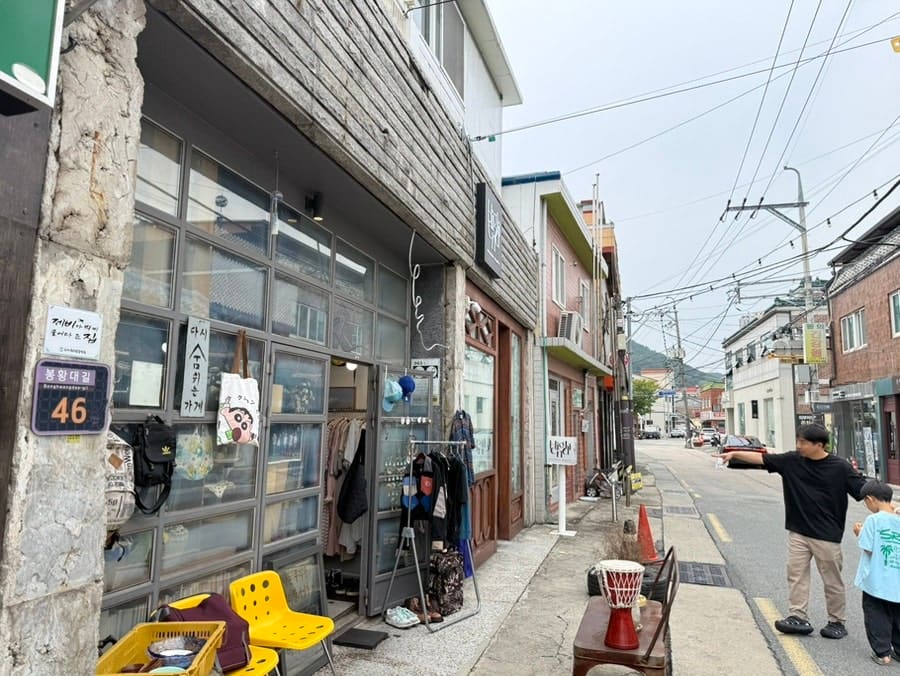 다녀온 블로거 dlwldus3213이 골목 초입에서 찍은 사진입니다. 돌기둥에 박힌 봉황대길 46번지 표지판과, 그 옆 오래된 옷가게 진열창이 함께 담겼습니다.