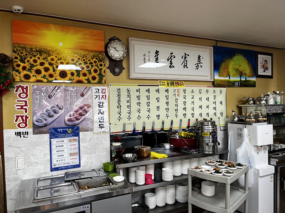 dalki154가 찍은 사진입니다. 창으로 볕이 드는 입식 테이블과, 해바라기 그림과 괘종시계가 걸린 주방 서비스존을 담았습니다.