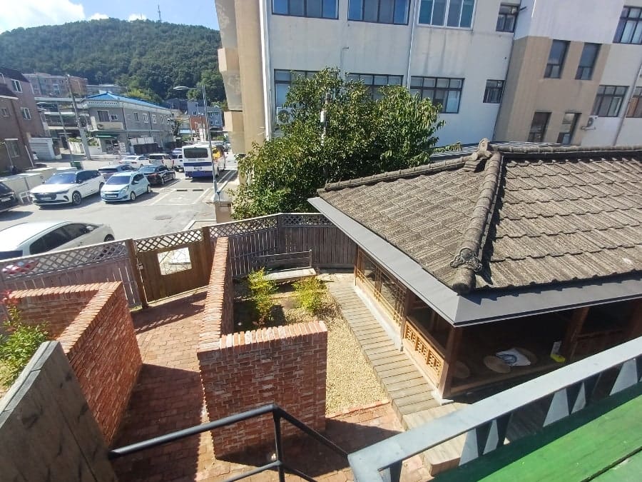 nerwoo36이 촬영한 원도심 골목입니다. 붉은 벽돌 건물과 오토바이가 세워진 좁은 길, 그리고 지붕 너머로 내려다본 낮은 집들이 이 골목이 오래 낡은 채로 있었음을 보여줍니다.