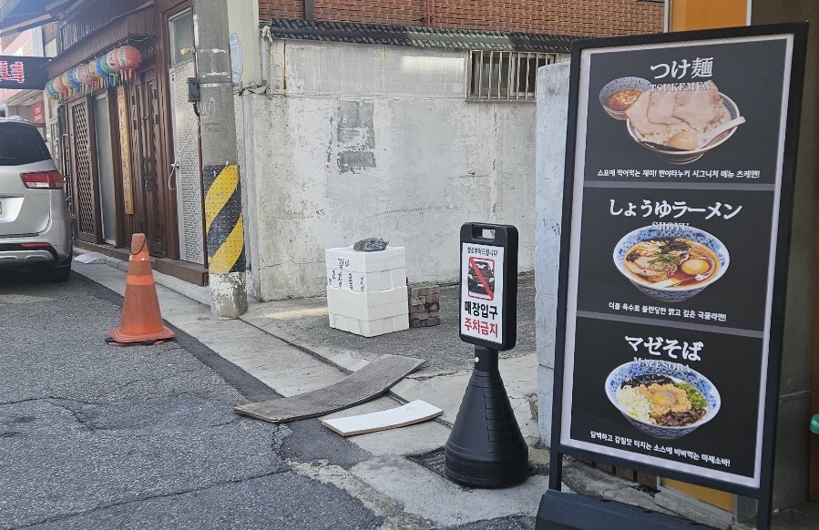 kimranju0519이 가게 앞 골목에서 담은 입간판입니다. 쯔케멘, 쇼유라멘, 마제소바가 나란히 그려진 메뉴판 옆으로,