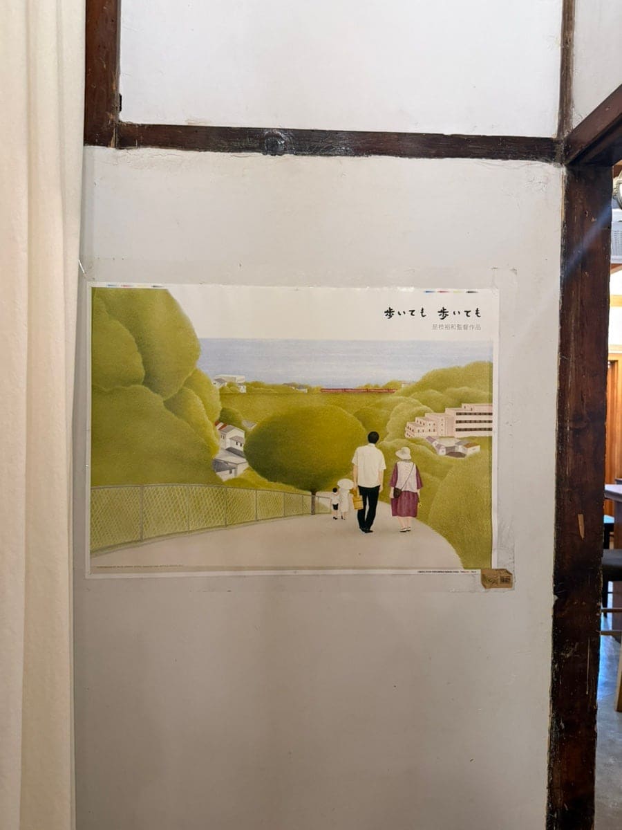 같은 사람이 담은 책장과 영화 포스터입니다. 낡은 책들이 꽂힌 선반 아래 작은 소파 자리가 있고,