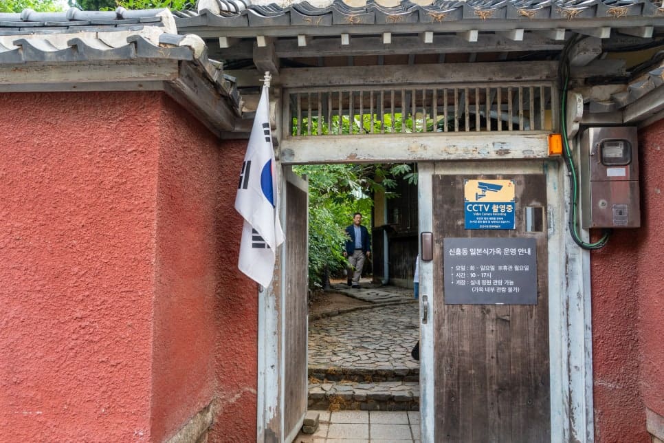 agi45가 찍은 대문 안쪽과 정원입니다. 붉은 담장과 태극기, 운영시간 안내판이 한눈에 들어오고,