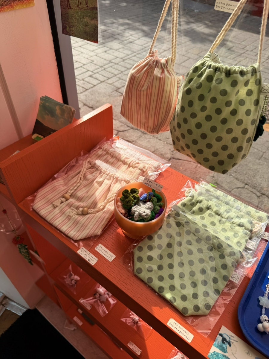 borivoribol이 찍은 가게 외관과 창가 진열입니다. 흰 건물 위에 걸린 주황색 'more_andmore' 간판과,