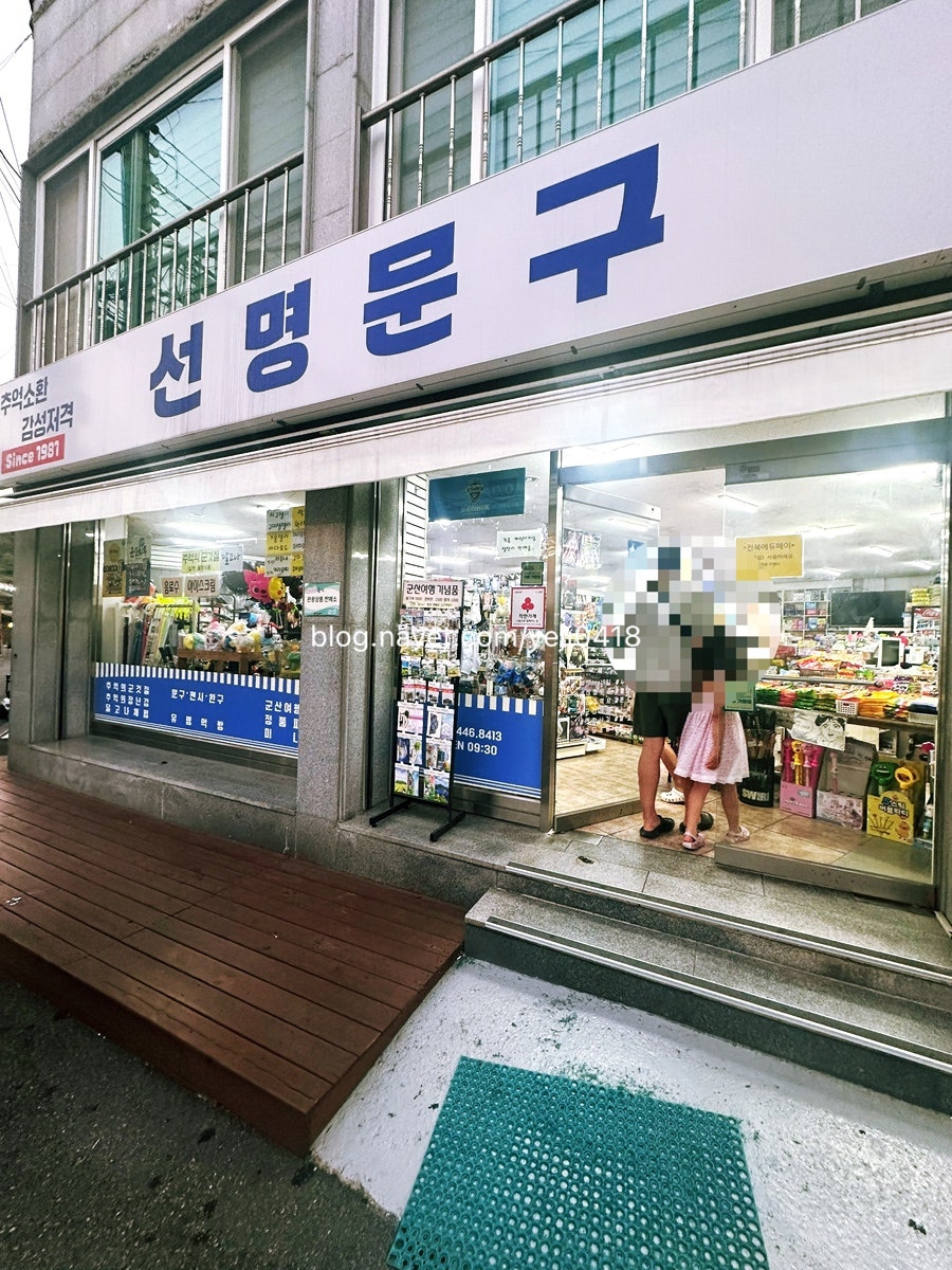 yeji0418이 찍은 가게 외관과 안쪽 진열대입니다. 파란 바탕에 흰 글씨로 적힌 '선명문구' 간판이 큰길에서도 눈에 띄고,