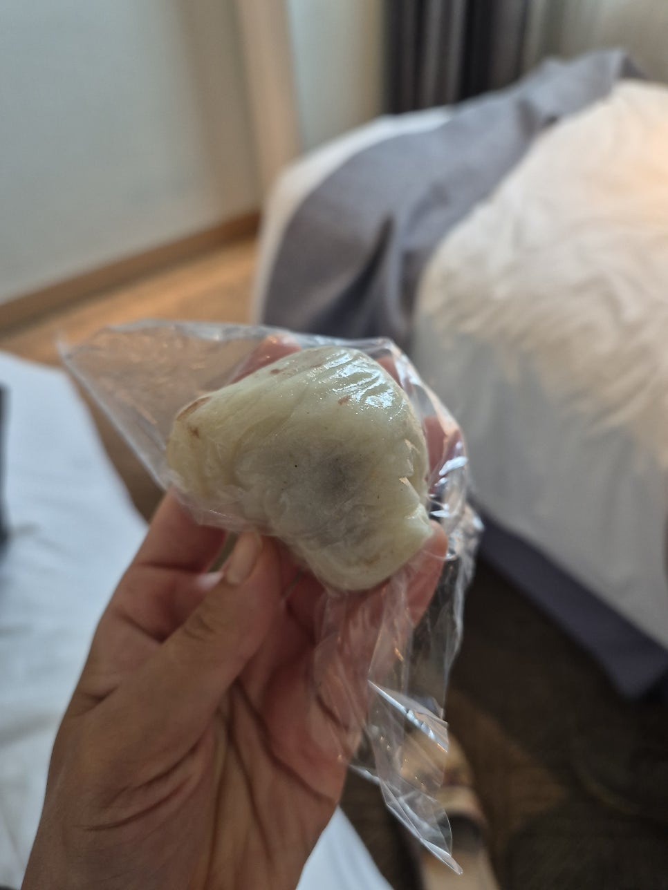 진열대 위로 두텁떡·절편·쑥떡이 색깔별로 쟁반에 담겨 있고, 손글씨로 쓴 가격표가 꽂혀 있습니다. 뒤쪽 벽에는 방송 출연 사진이 액자로 걸려 있습니다.