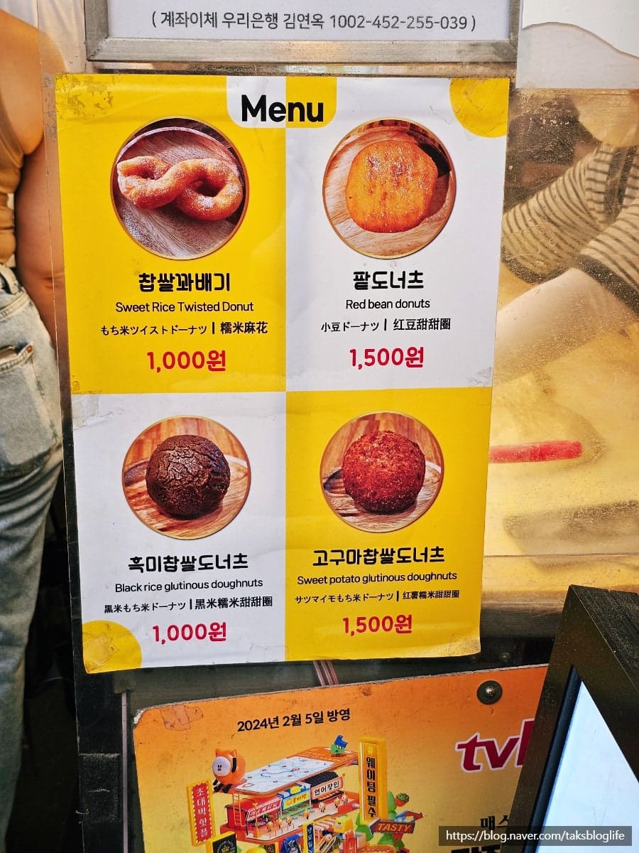 광장시장의 입구를 포함한 전경. 오래된 간판과 새로운 표지판이 겹쳐 있는 장면에서 시장의 오랜 역사가 읽힙니다. 여러 세대가 이곳을 지나왔습니다.