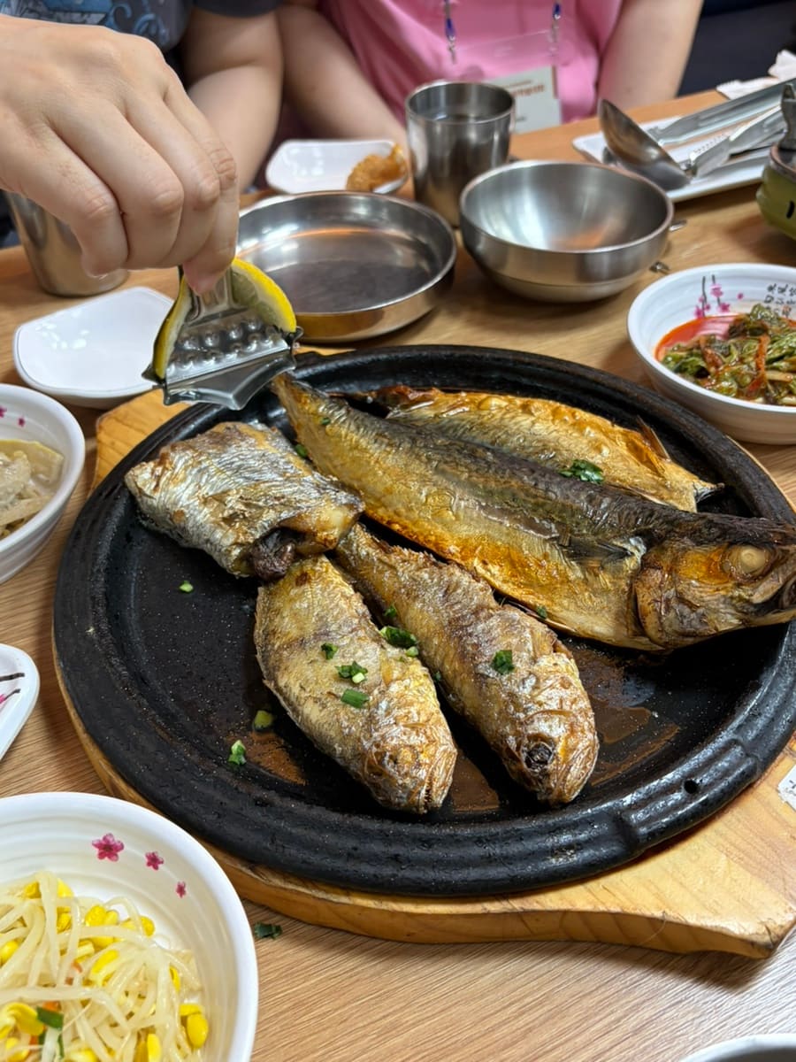 부모님을 모시고 갔다는 zzzzzzz_qzzz가 찍은 생선모둠구이입니다. 고등어·갈치·조기가 오른 불판에 레몬을 직접 짜 넣는 손길과,