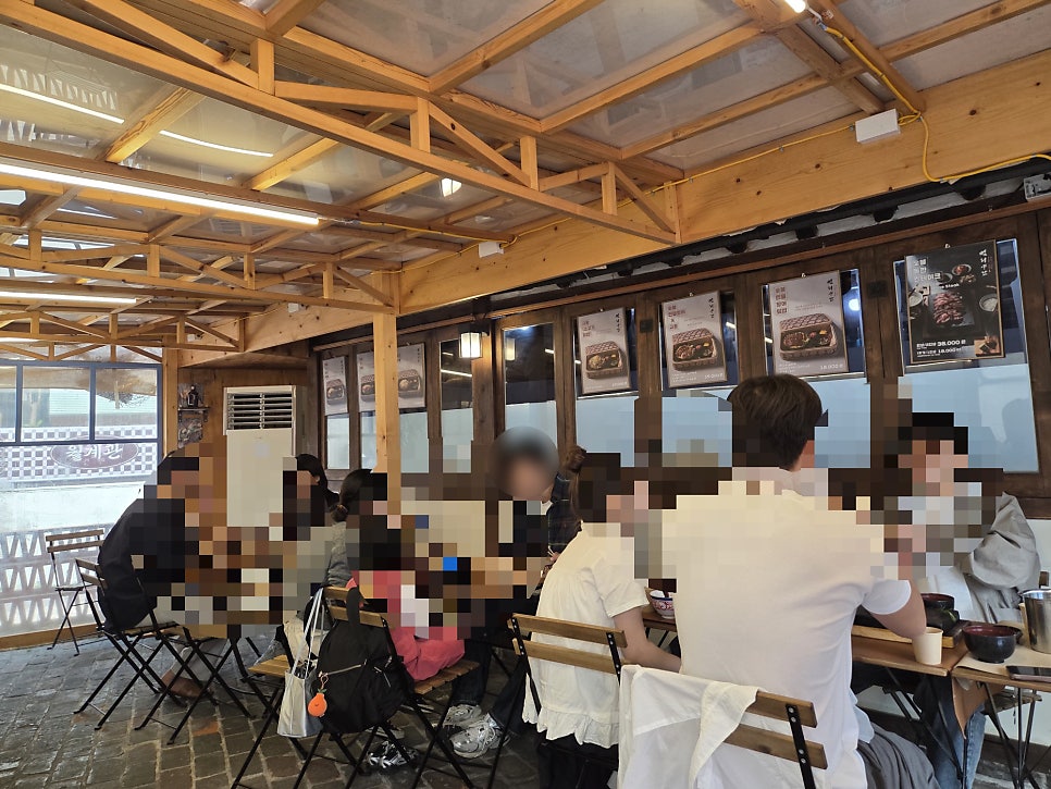 vldhsk213이 담은 저녁 시간의 북적이는 실내입니다. 벽화 속 호랑이 두 마리가 가득 들어찬 테이블을 내려다보는 모습이 이 골목의 저녁 풍경을 보여줍니다.